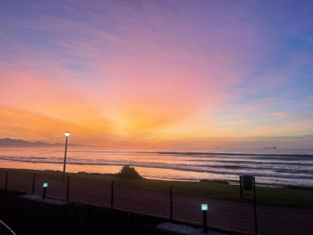 Stunning sunset over the ocean with golden sky and calm waters from property