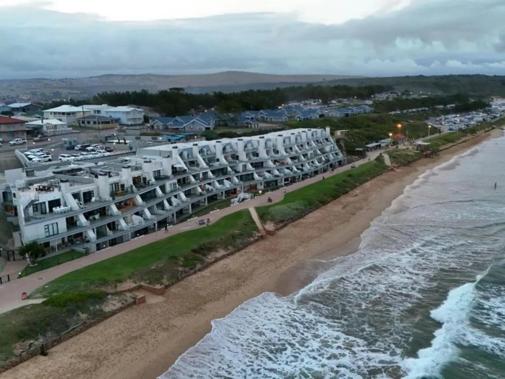 Beachfront apartment building overlooking sandy beach and ocean waves