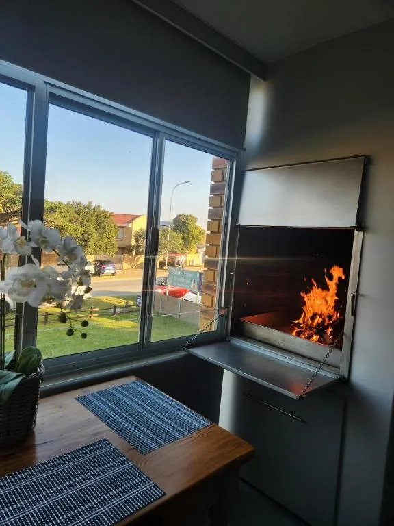 Outdoor seating area with fireplace overlooking garden and lawn