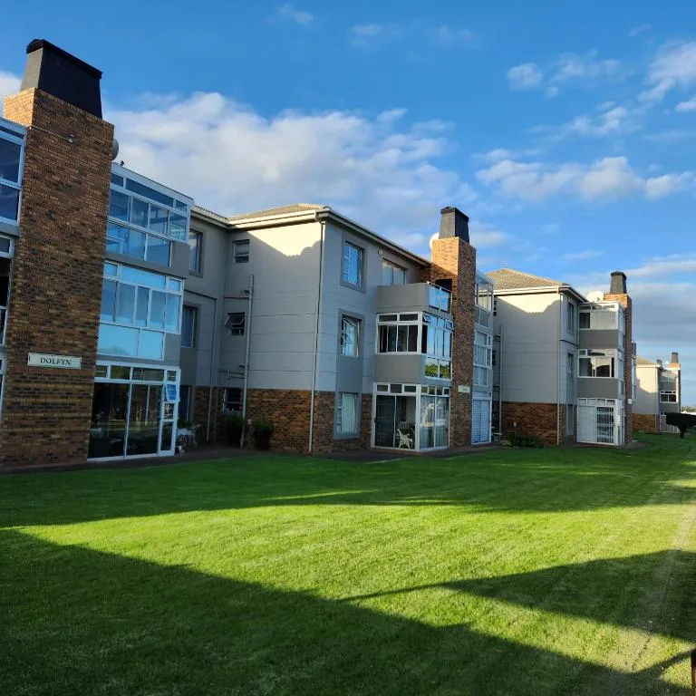Modern apartment building with brick chimneys and manicured lawn frontage