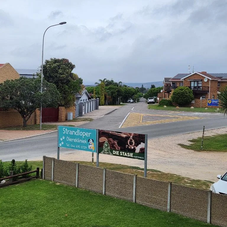 Residential street entrance with signage and brick properties visible