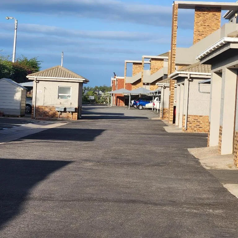 Brick and cream holiday apartment complex with driveway and landscaping