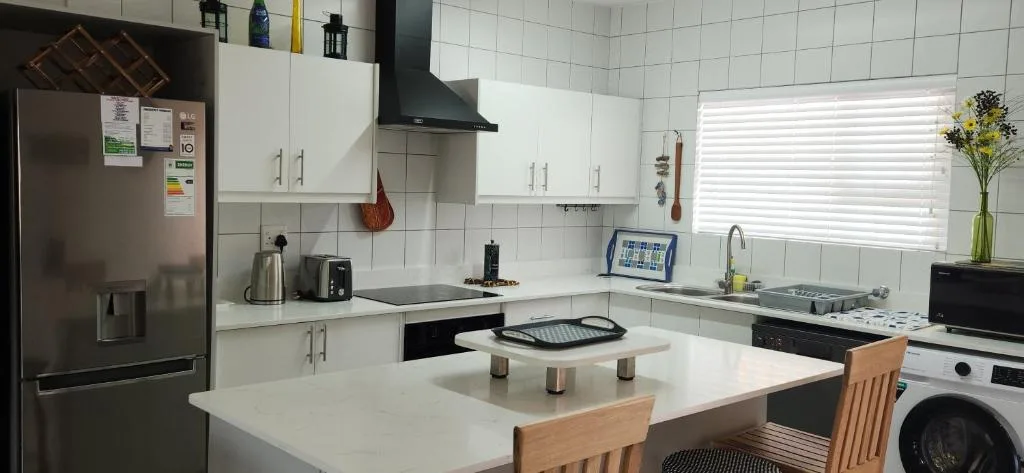 Modern kitchen with white cabinetry, stainless steel appliances, and island counter