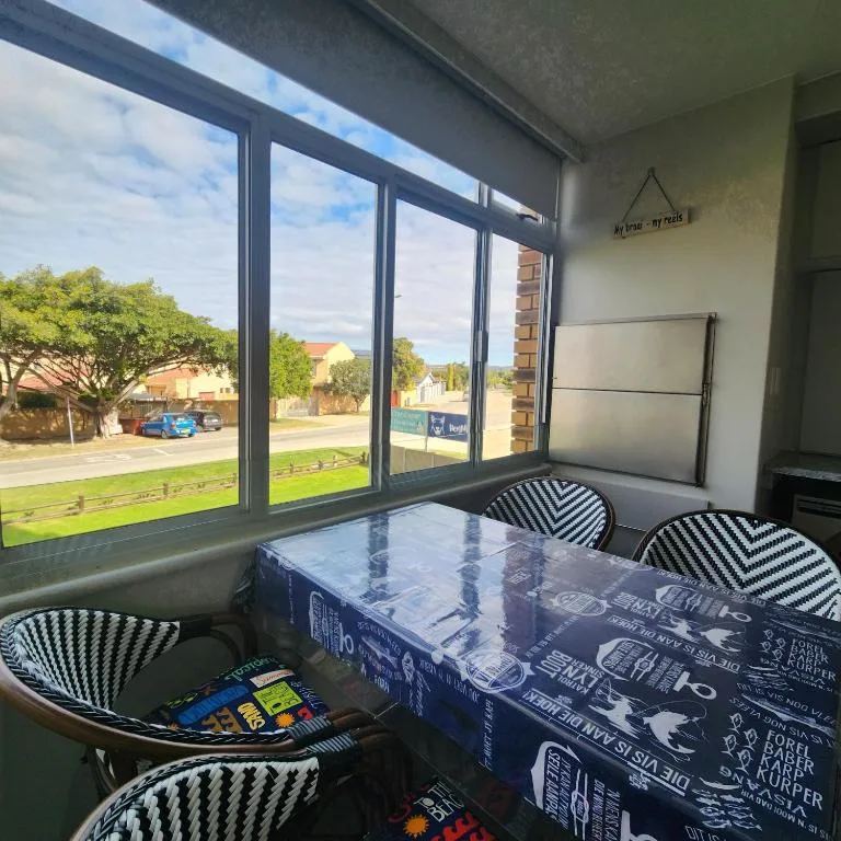 Modern lounge with striped chairs, table, large windows overlooking street