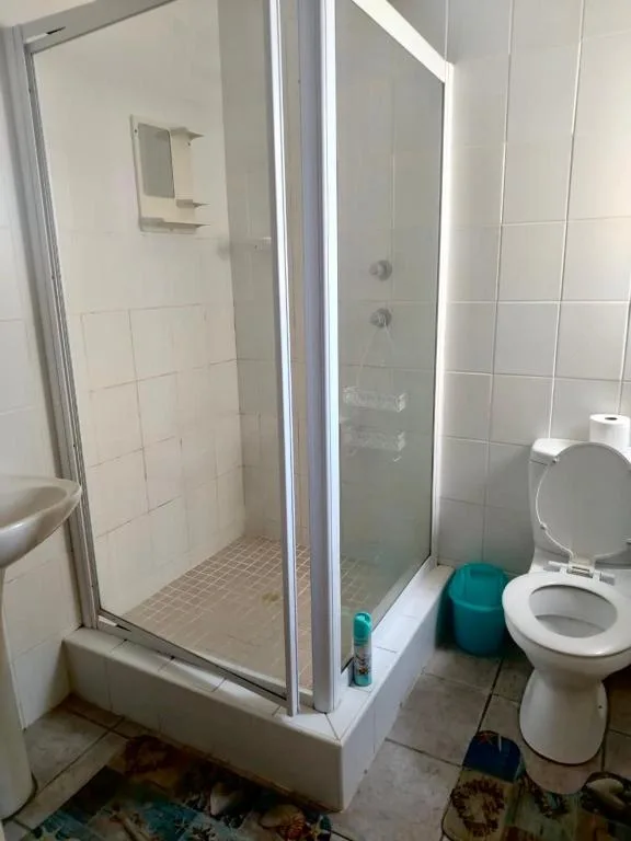 Modern bathroom with enclosed shower cubicle and white toilet fixture