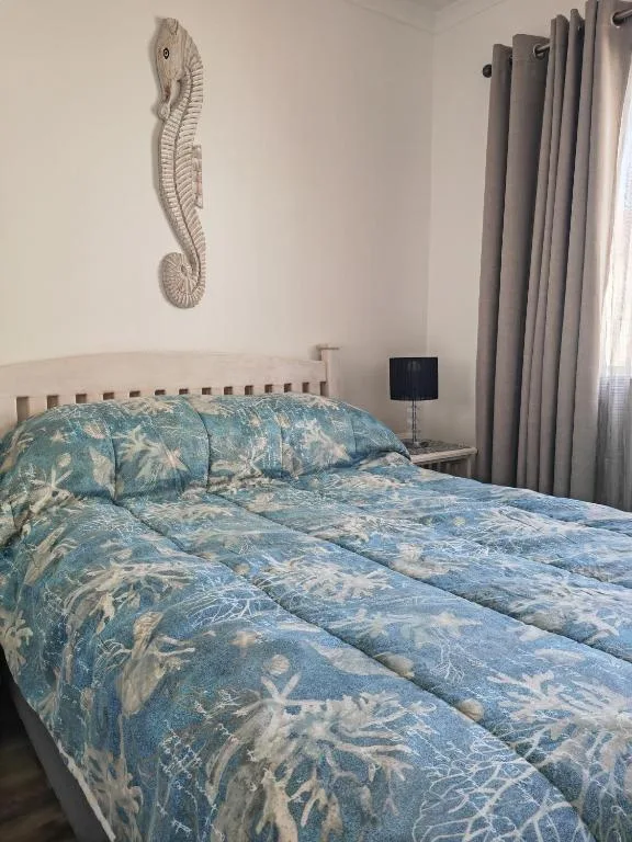 Cozy bedroom with blue coral-patterned bedding and seahorse wall art