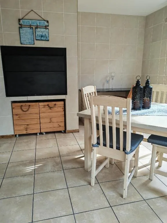 Spacious lounge with dining table, wooden furniture, and entertainment setup