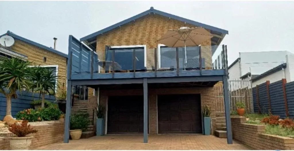 Modern brick home with double garage and elevated deck with umbrella