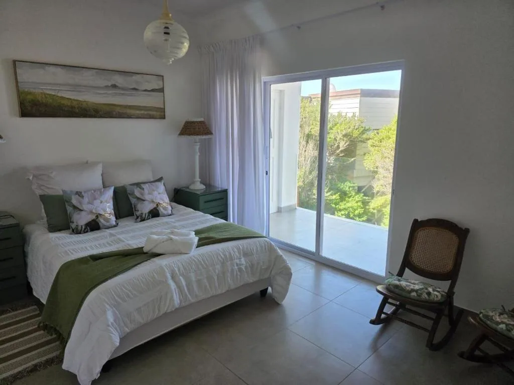 Bright bedroom with queen bed, garden view through sliding doors