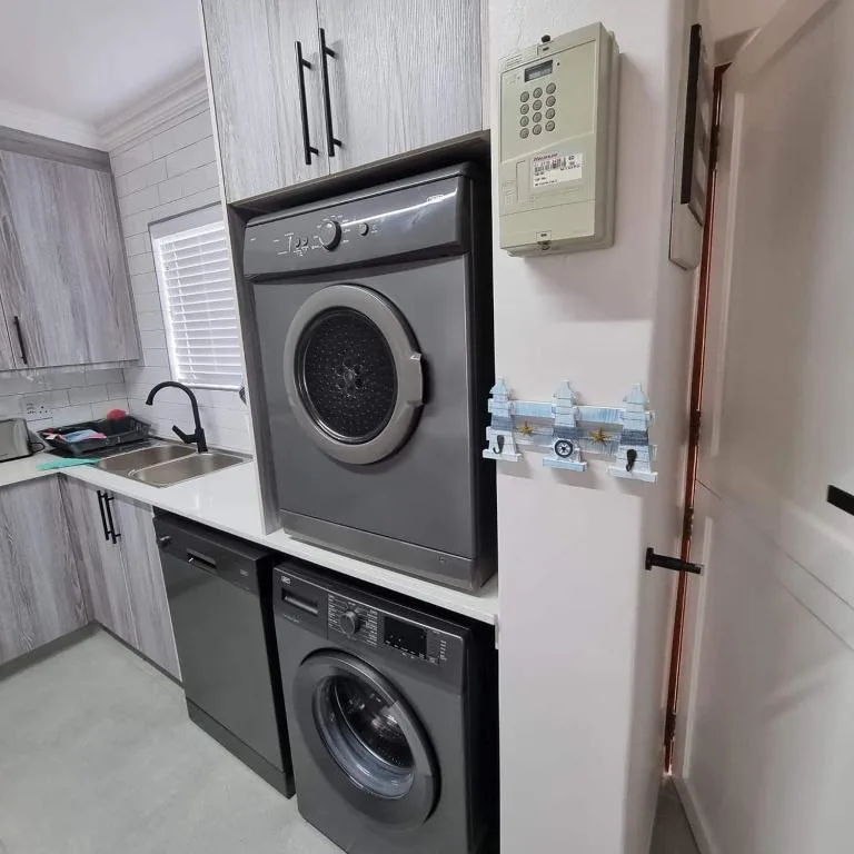 Stacked washer and dryer with sink in compact laundry utility room