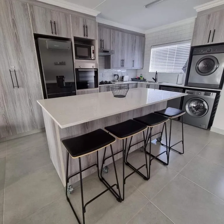 Modern kitchen with island counter, stainless steel appliances, and bar seating