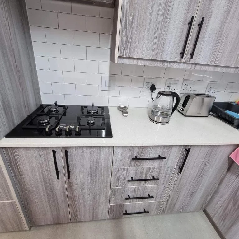 Modern kitchen with gas cooktop, white subway tile backsplash, kettle and toaster