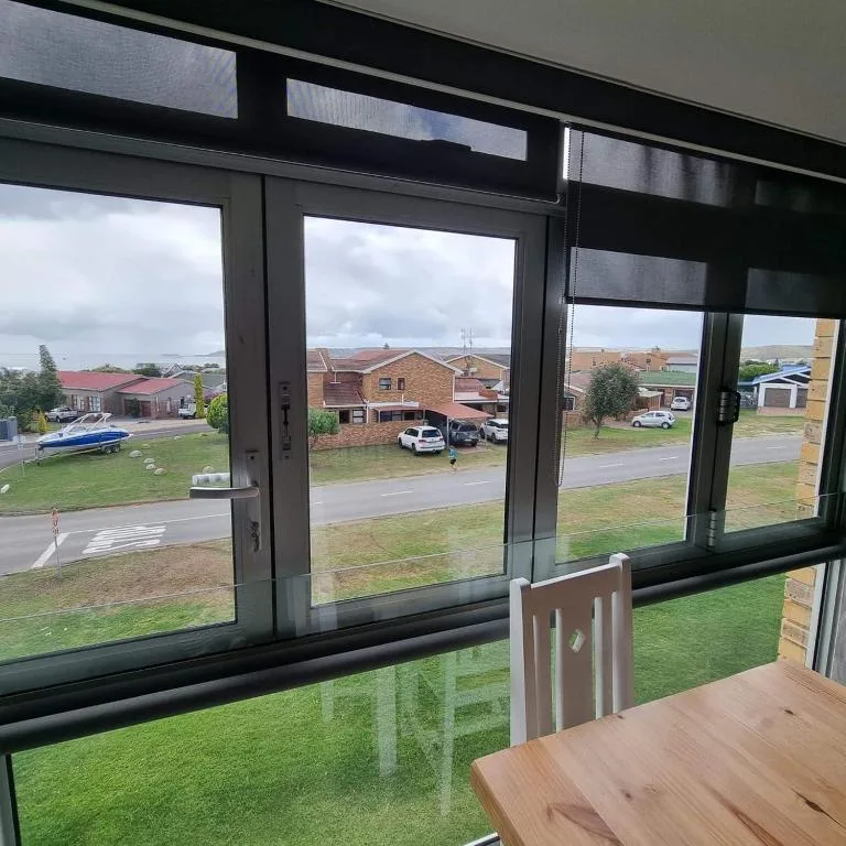 Scenic suburban view through large windows overlooking neighborhood gardens and houses