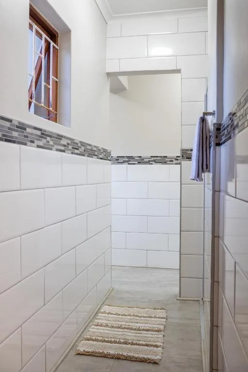 Modern bathroom with walk-in shower, white subway tiles, and natural light