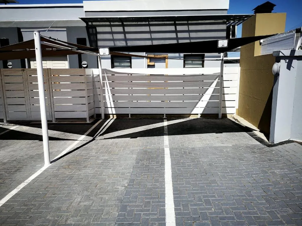 Modern covered carport with pergola and paved parking area