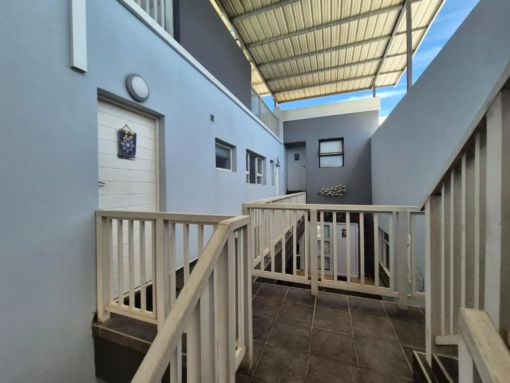 Modern wooden-railed deck with corrugated roof shade structure