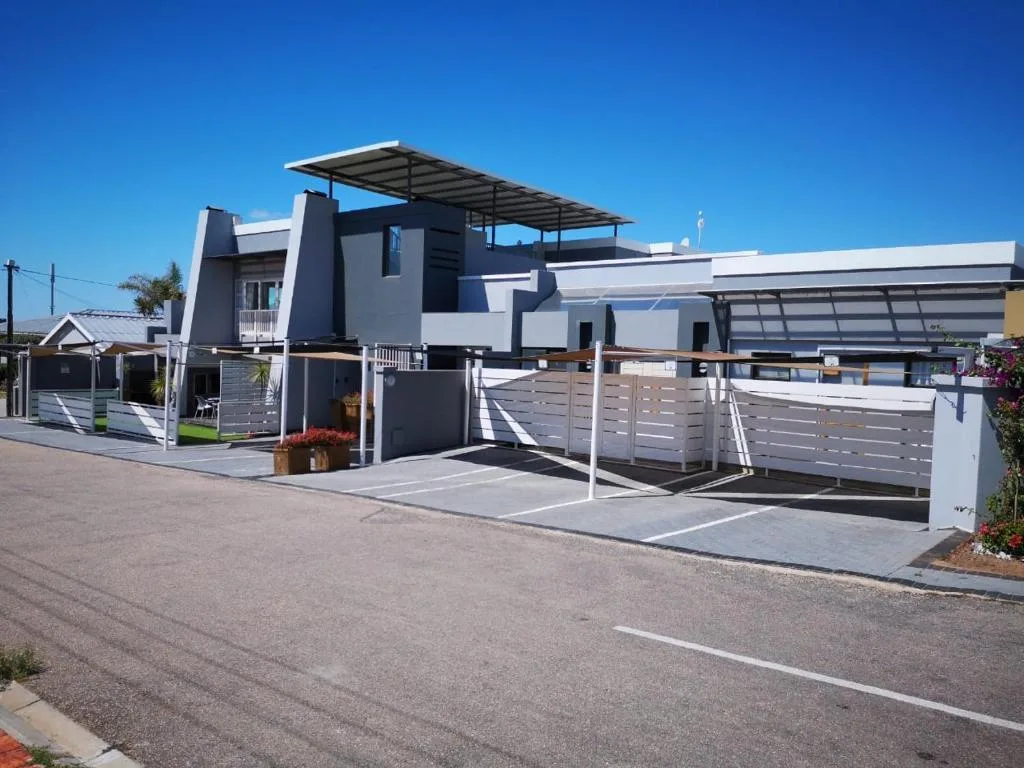 Modern aparthotel with angular architecture and metal pergola driveway entrance