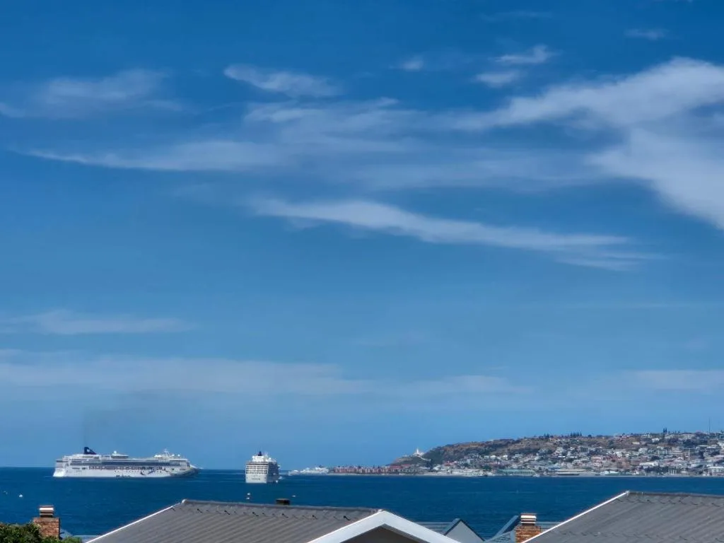 Scenic coastal view with cruise ships and beachfront town under blue sky