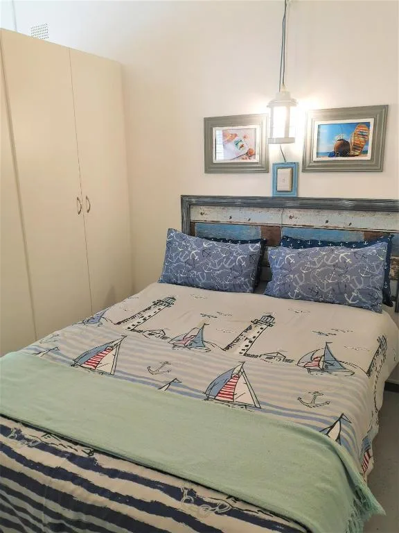 Bedroom with sailboat-themed bedding and nautical wall decor