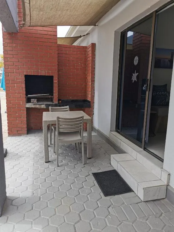 Covered patio with dining table and brick braai area
