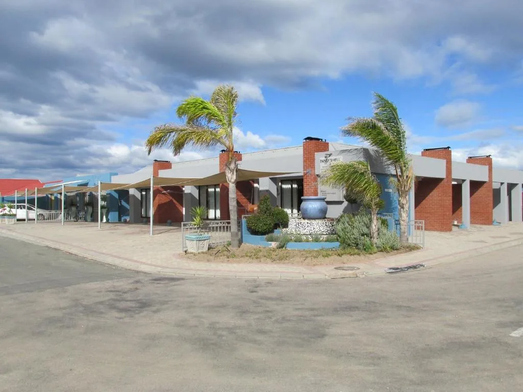 Red brick and blue modern apartment building with palm trees and covered entrance