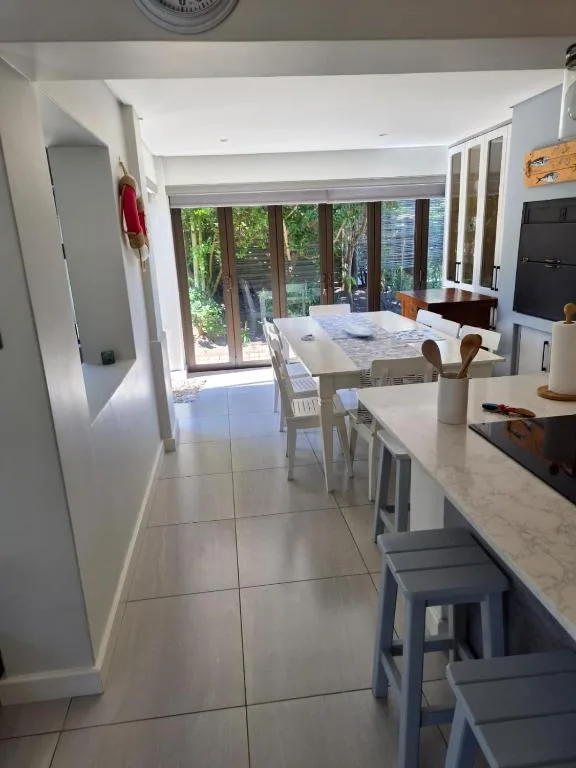 Modern kitchen with dining area and glass doors to garden deck