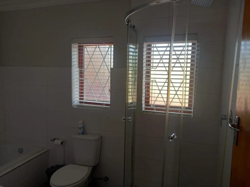 Clean bathroom with toilet, vanity, and large walk-in shower enclosure