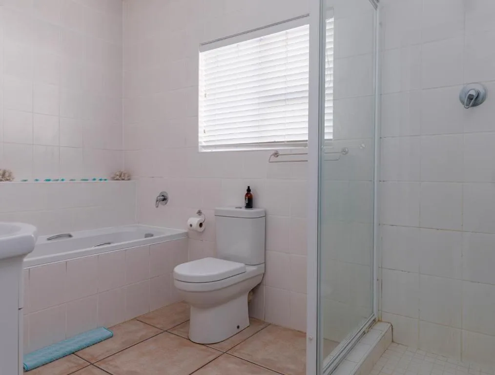 Clean bathroom with bathtub, toilet, shower enclosure and window