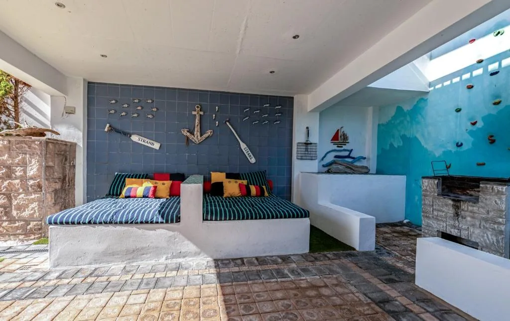 Nautical-themed bedroom with striped bed and colorful pillow accents