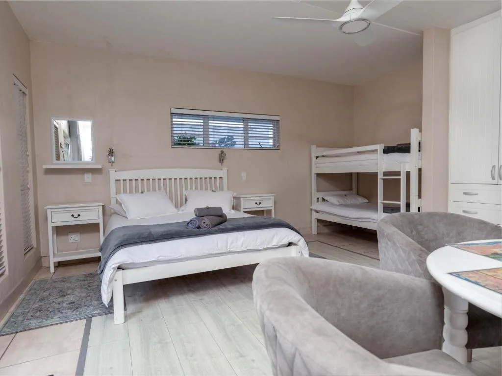 Spacious bedroom with queen bed, bunk bed, and comfortable seating area