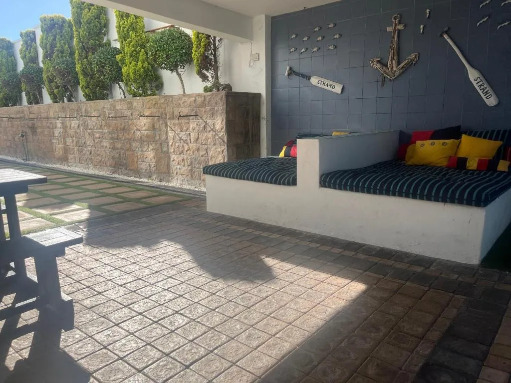 Covered patio with built-in seating, nautical wall decor, and garden views