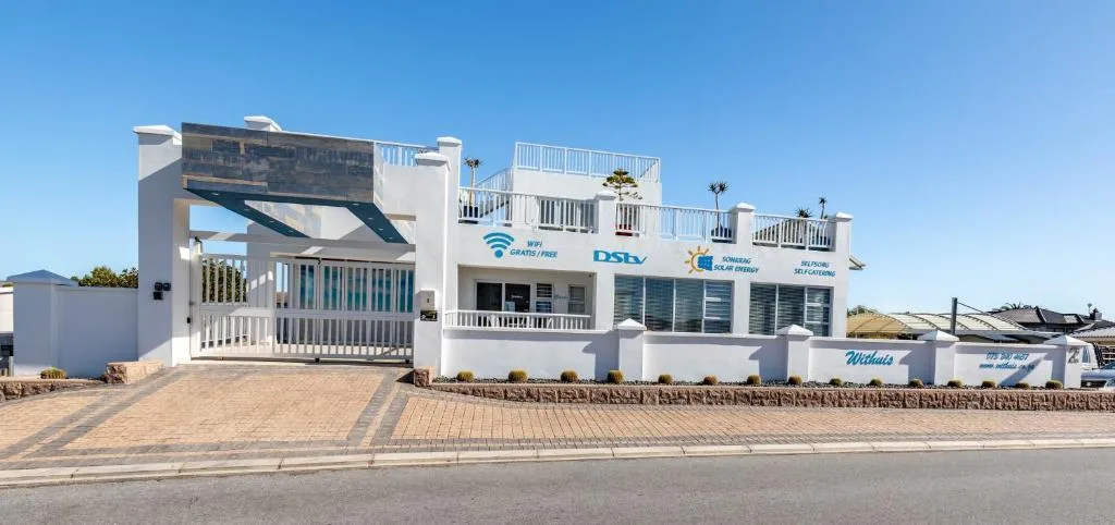 Modern white beachfront apartment building with multiple decks and ocean views