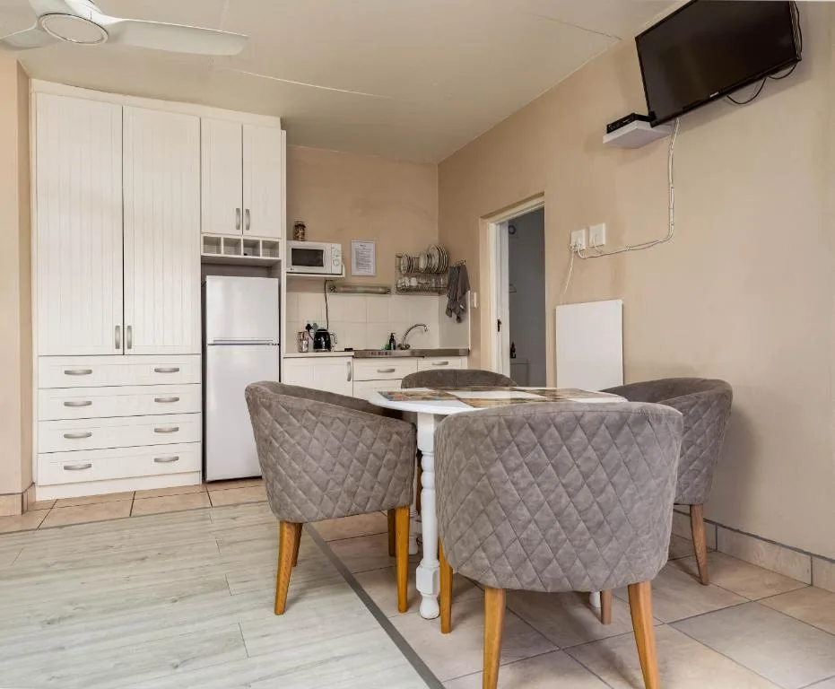 Open-plan kitchen and dining area with white cabinetry and modern appliances