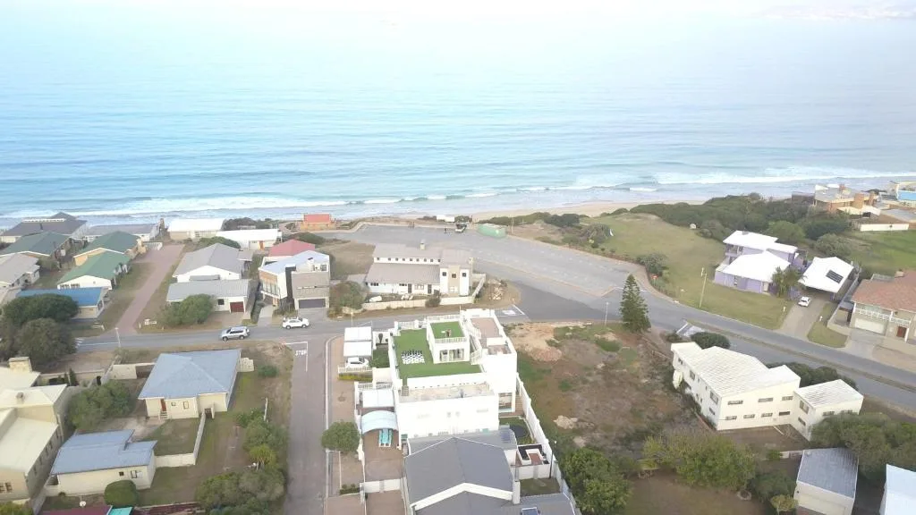 Aerial view of beachfront property with ocean and coastal settlement visible