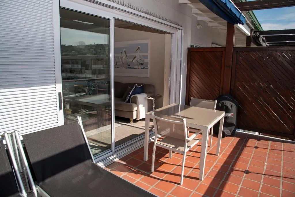 Sunny terracotta patio with outdoor dining table and lounge access