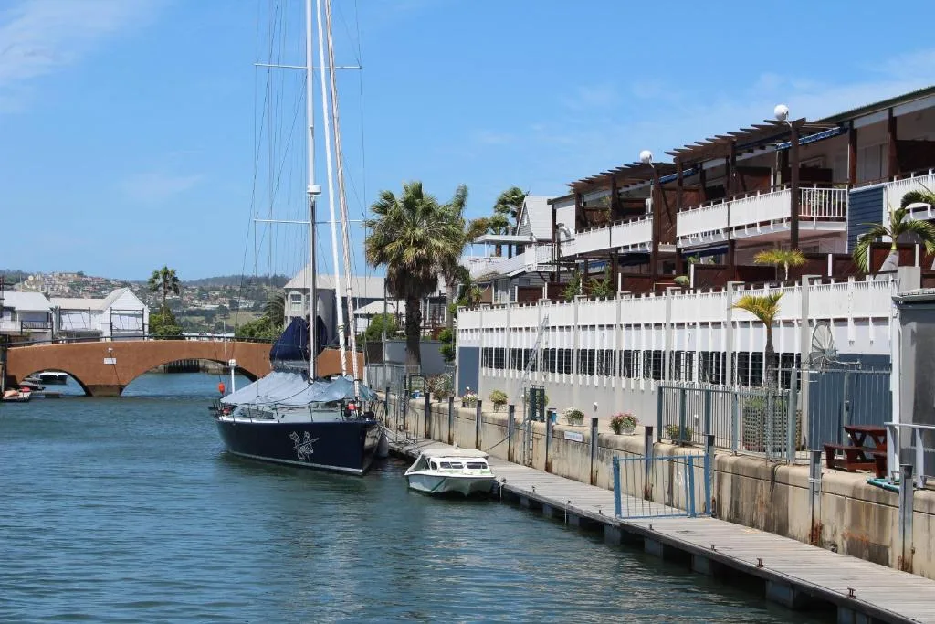 Waterfront apartment building with sailboat moored at private jetty
