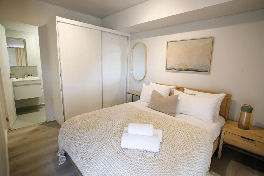 Modern bedroom with queen bed, ensuite bathroom, and contemporary furnishings