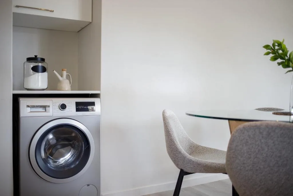 Modern washing machine with countertop storage and kitchen amenities