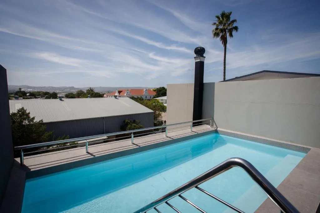 Rooftop swimming pool with metal railings overlooking Knysna townscape
