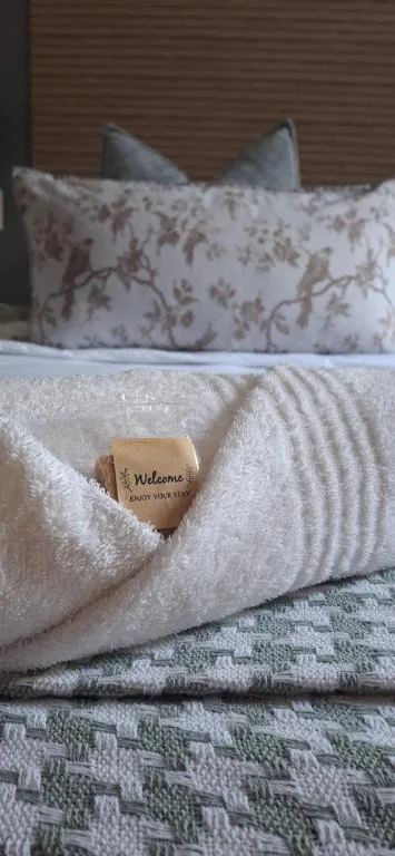 Inviting bed with decorative pillows and welcome chocolate on white linens