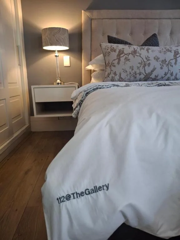 Elegantly styled bedroom with upholstered headboard and ambient bedside lighting