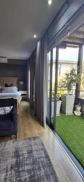 Modern studio bedroom with bed, sliding doors opening to private deck garden
