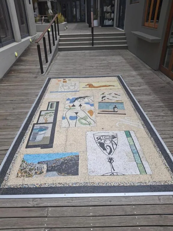 Wooden deck with decorative mosaic artwork and black railings