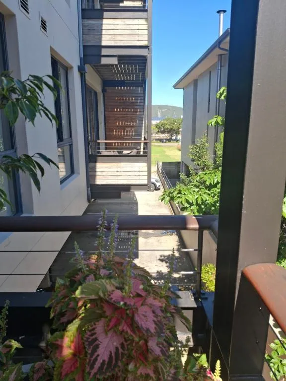 Modern patio walkway with potted plants and mountain views beyond
