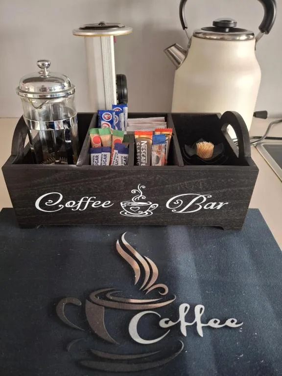 Coffee bar station with kettle, plunger, sugar and condiments organized neatly