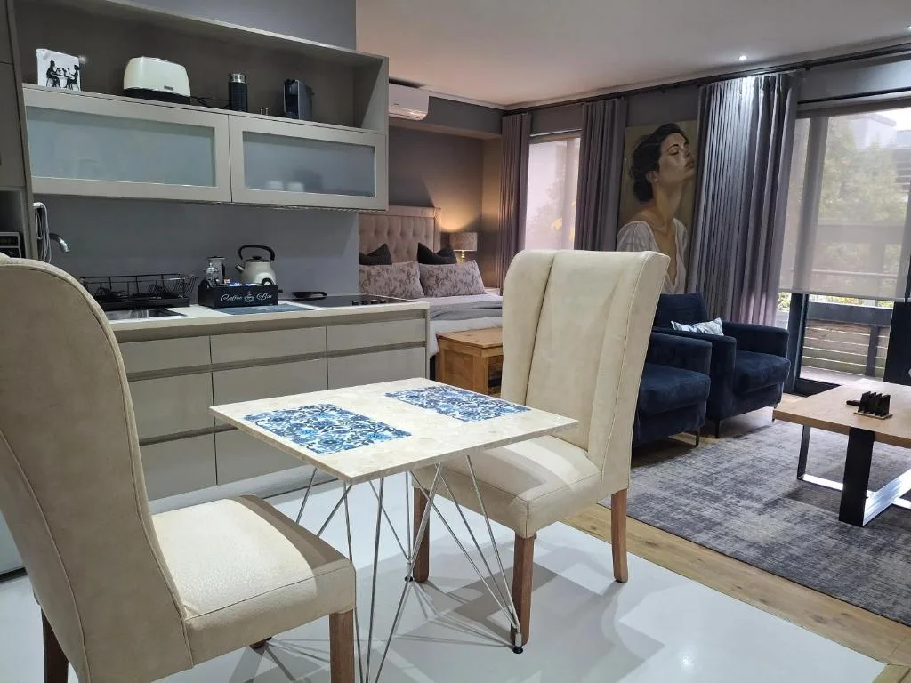 Modern dining table with cream chairs in open-plan apartment interior