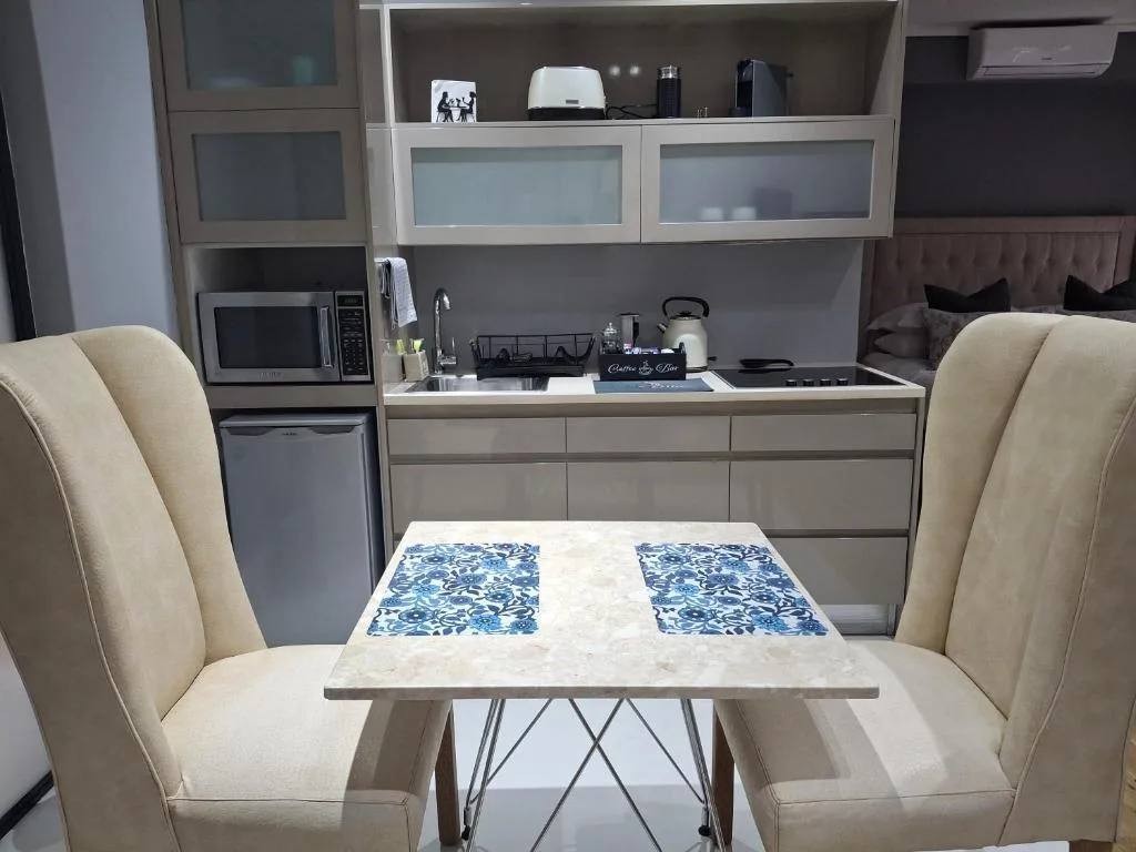 Modern kitchen with gray cabinetry, stove, microwave, and dining table