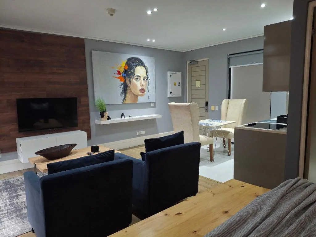 Modern lounge with black sofa, TV, and artistic wall decor