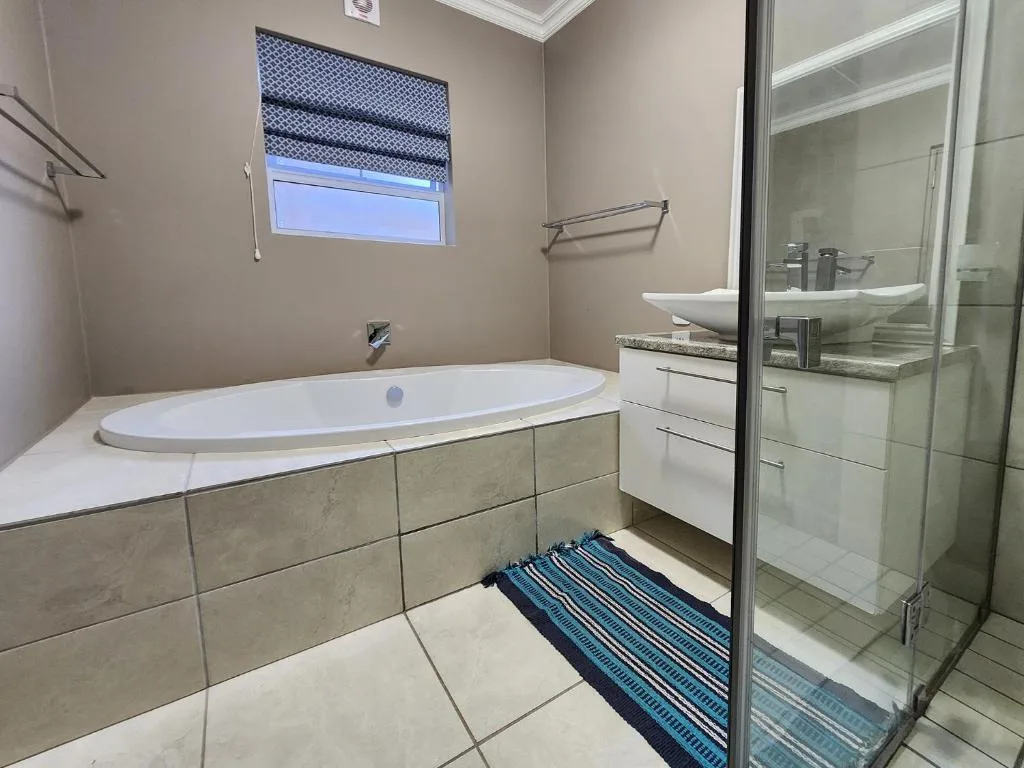 Modern bathroom with oval soaking tub, walk-in shower, and vanity