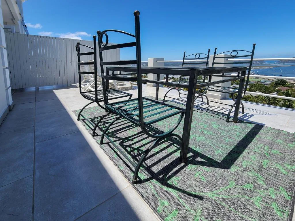 Elevated deck with black loungers overlooking Knysna Lagoon and coastline